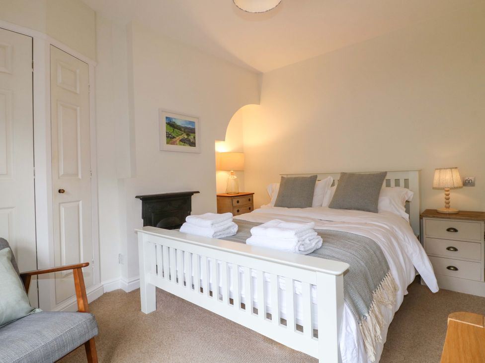 A bedroom with a bed and armchair at 9 New Lumford