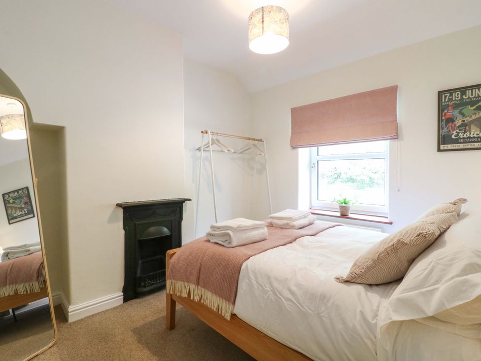 A bedroom with a bed and a clothes rack at 9 New Lumford