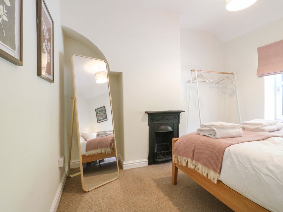 A bedroom with a bed and mirror at 9 New Lumford