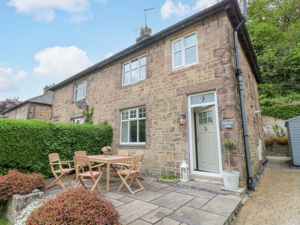 A cottage with a garden and seating area at Lumford Mill Cottage in Bakewell
