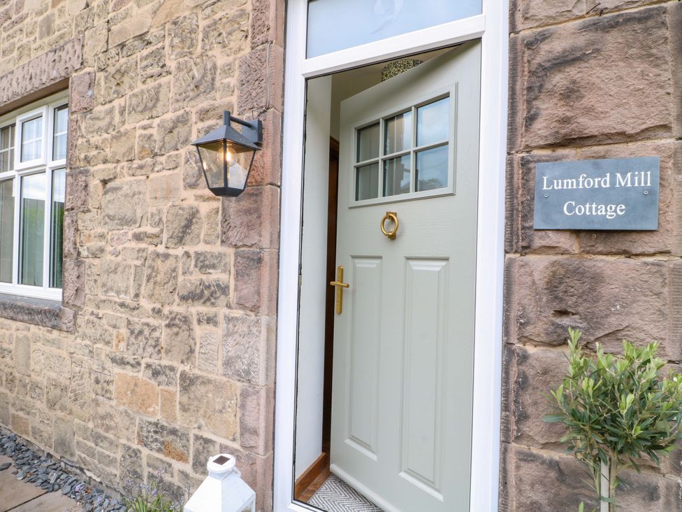 An entrance with a door and sign at Lumford Mill Cottage Bakewell