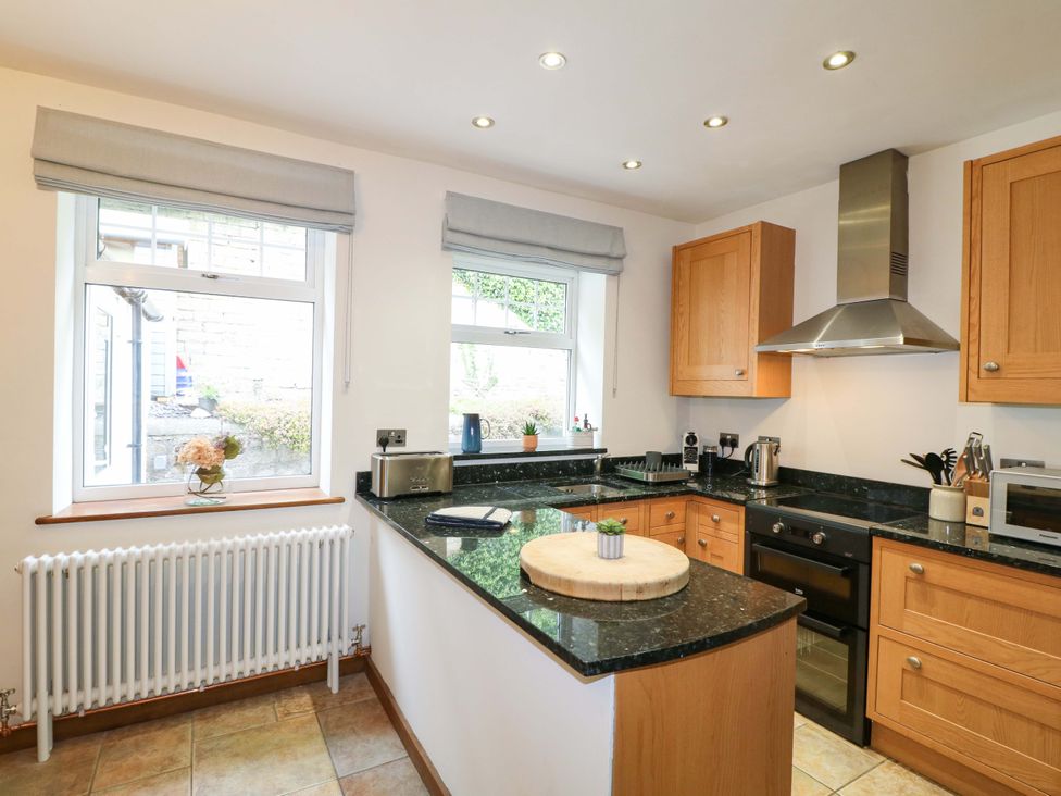 A kitchen with cabinets and appliances at Lumford Mill Cottage in Bakewell