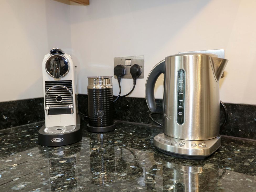 A kitchen with a coffee machine, milk frother, and electric kettle at Lumford Mill Cottage, Bakewell