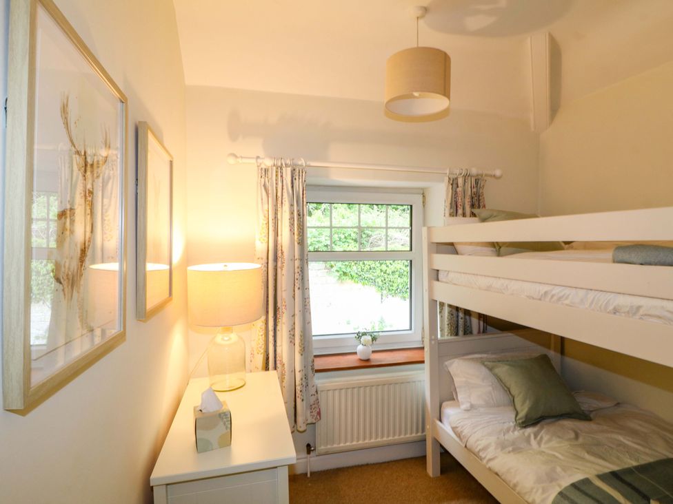 A bedroom with a bunk bed and lamp at Lumford Mill Cottage Bakewell