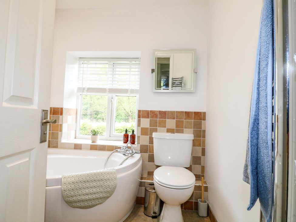 A bathroom with a bathtub and toilet at Lumford Mill Cottage in Bakewell