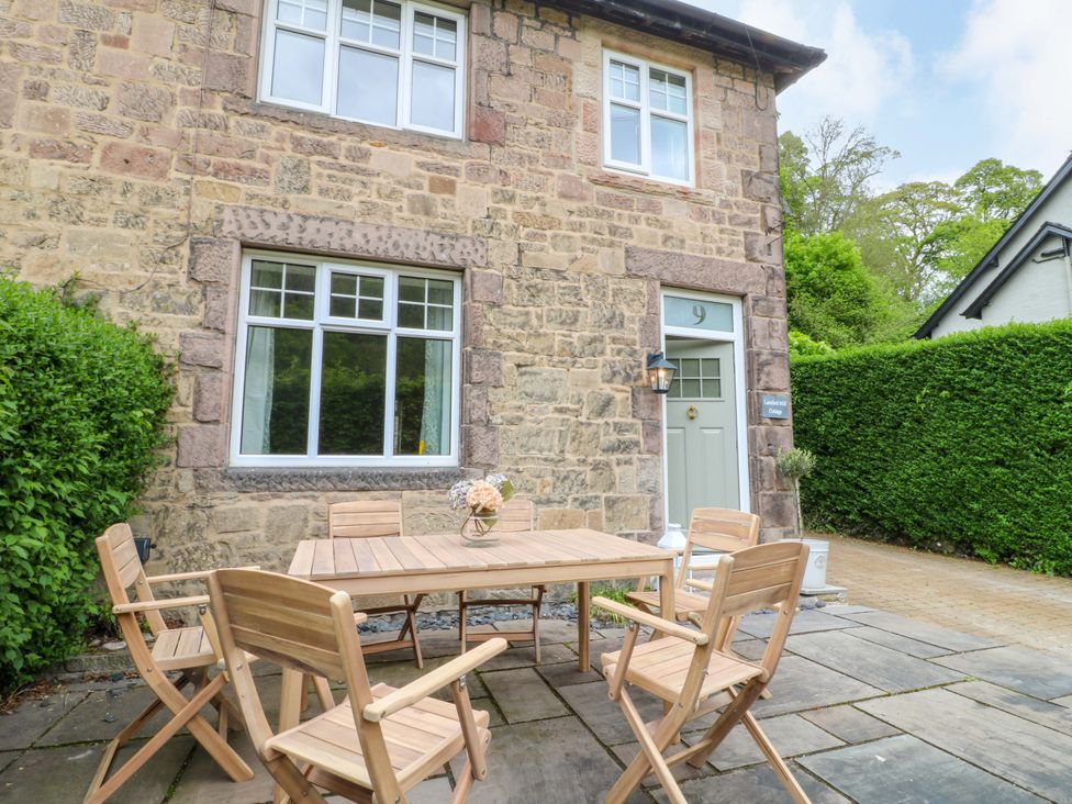An outdoor seating area with a table and chairs at Lumford Mill Cottage in Bakewell