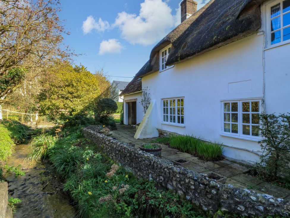 A house with a garden and stream at Plush Cottage in Dorchester