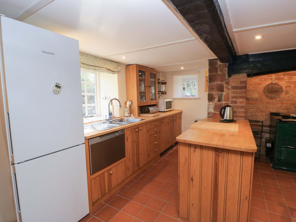 A kitchen with cabinets and appliances at Plush Cottage in Dorchester