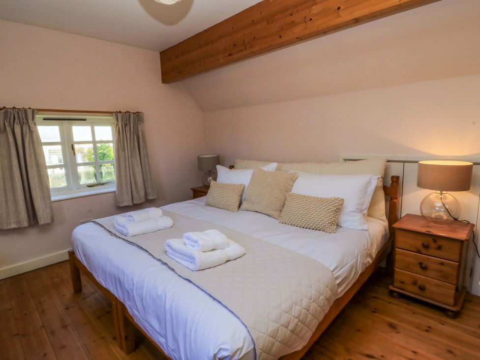 A bedroom with a bed and nightstand at Plush Cottage in Dorchester