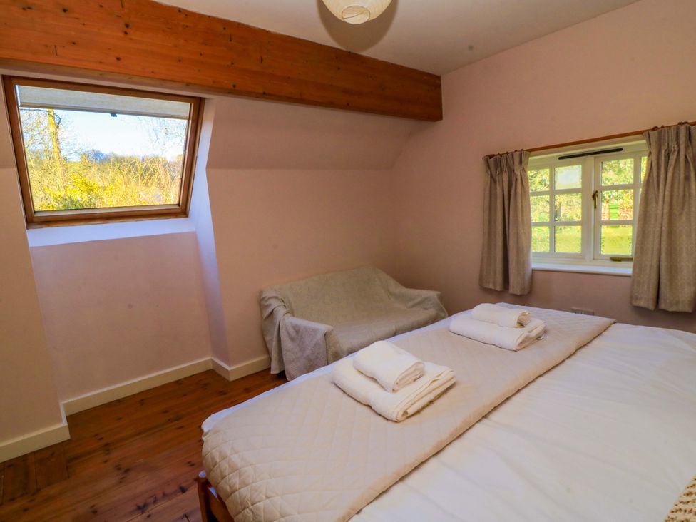 A bedroom with a bed and a sofa at Plush Cottage in Dorchester
