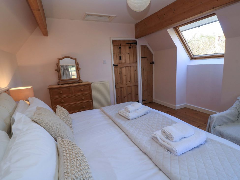 A bedroom with a bed and dresser at Plush Cottage in Dorchester