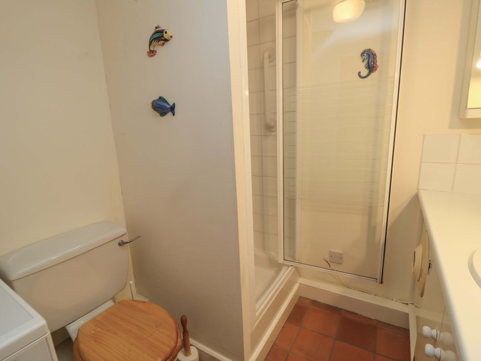 A bathroom with a toilet, shower, and sink at Plush Cottage Dorchester