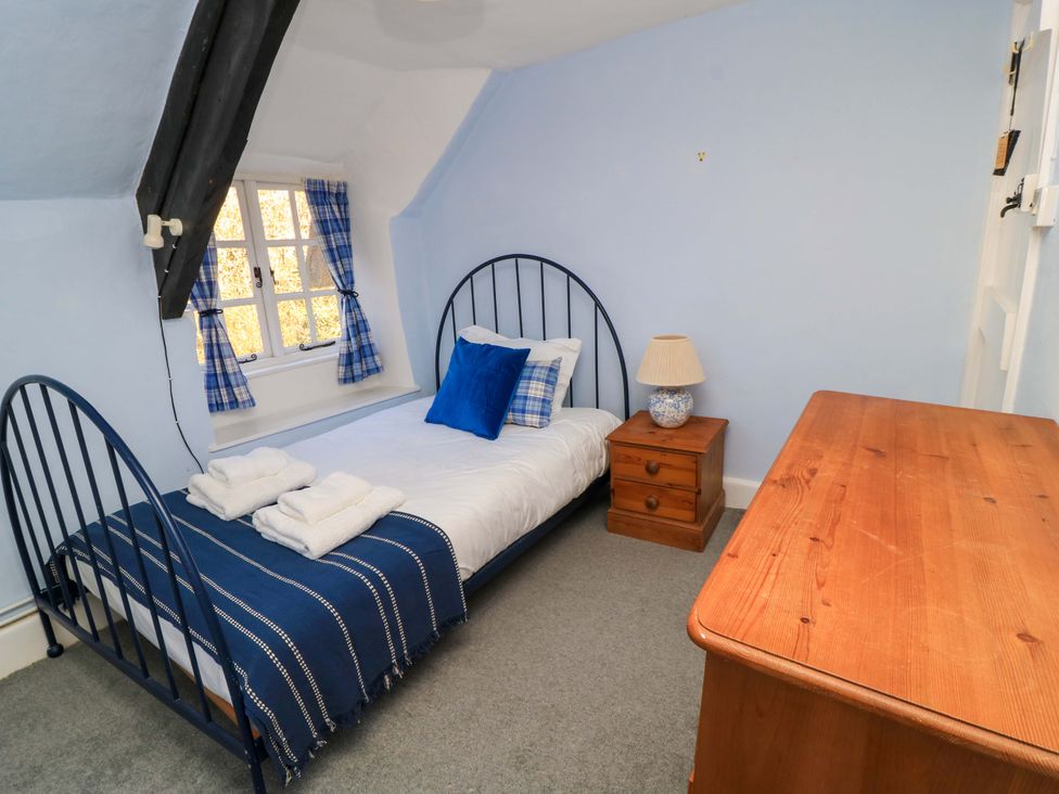 A bedroom with a bed and a chest of drawers at Plush Cottage in Dorchester