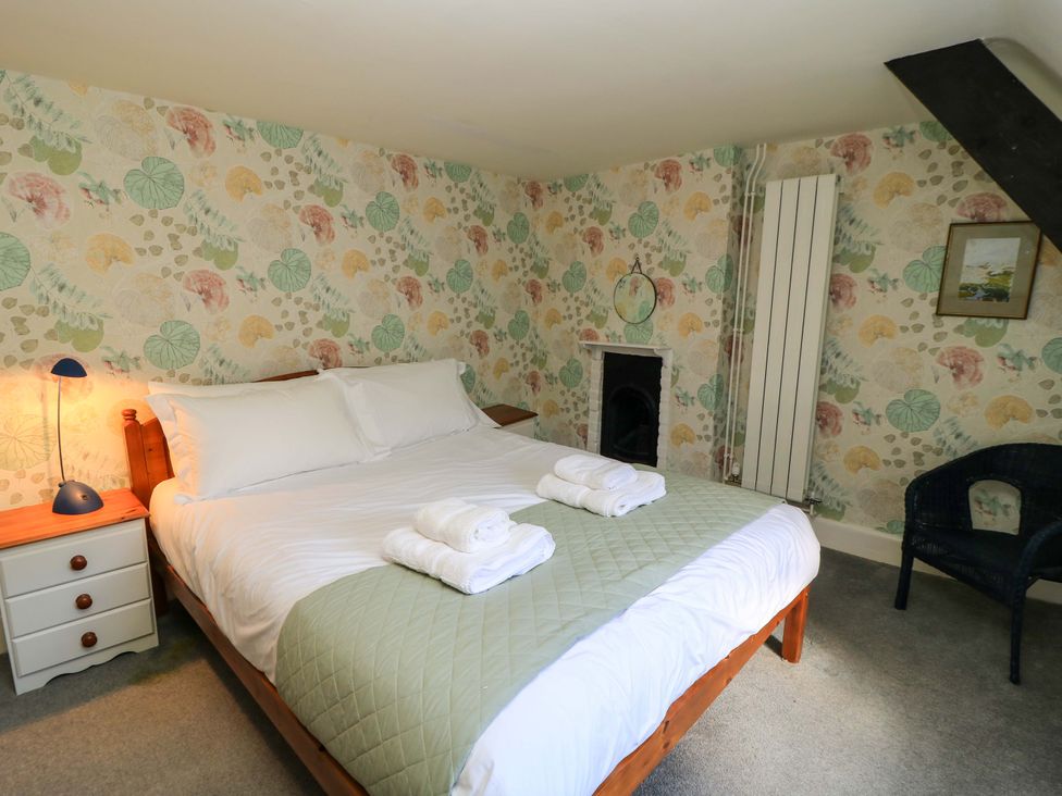 A bedroom with a bed and nightstand at Plush Cottage in Dorchester