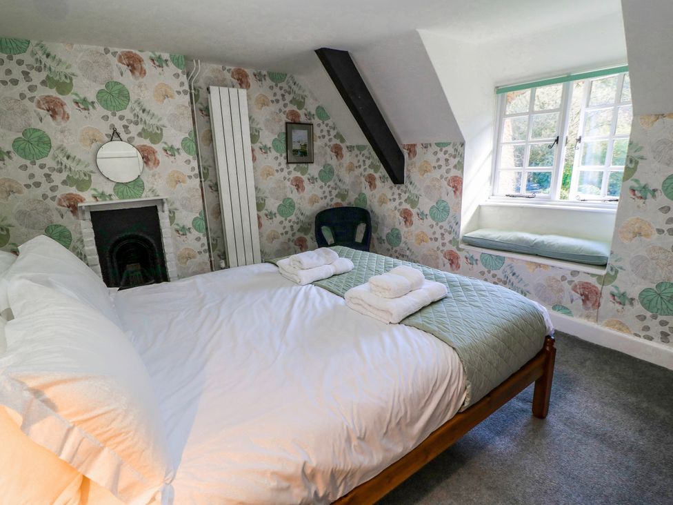 A bedroom with a bed and towels at Plush Cottage near Hazelbury Bryan