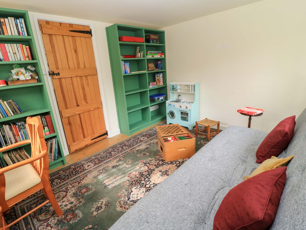 A snug with bookshelves and a play kitchen at Plush Cottage in Plush