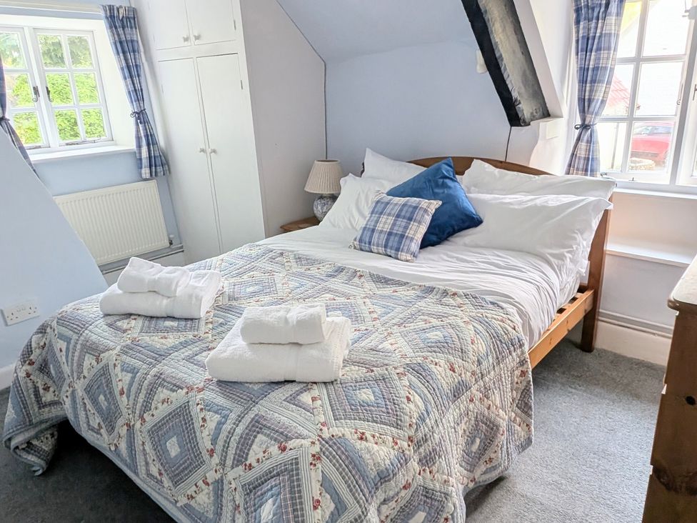 A bedroom with a bed and wardrobe at Plush Cottage in Plush