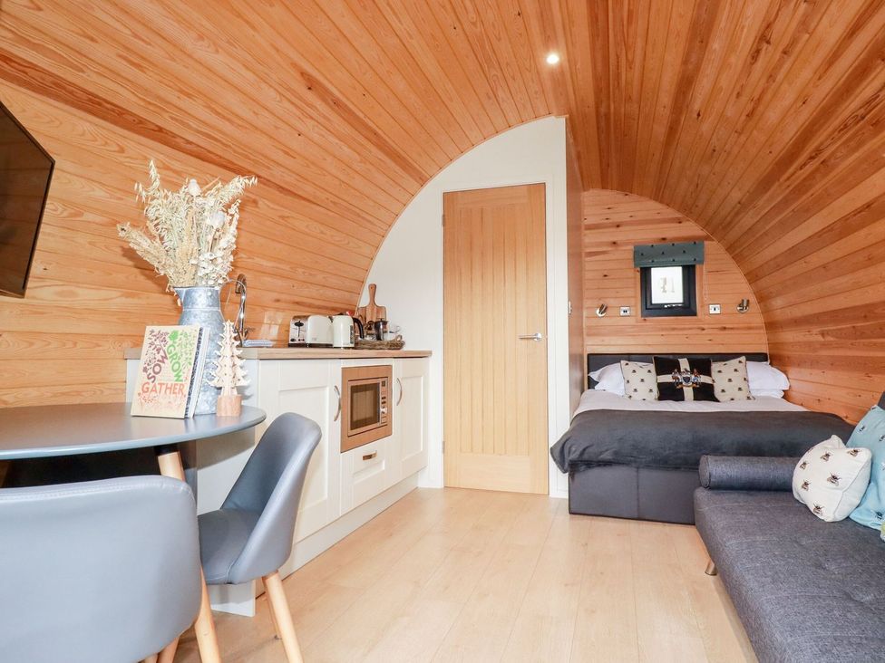 A living area with kitchenette and bed at Barry in Polgooth
