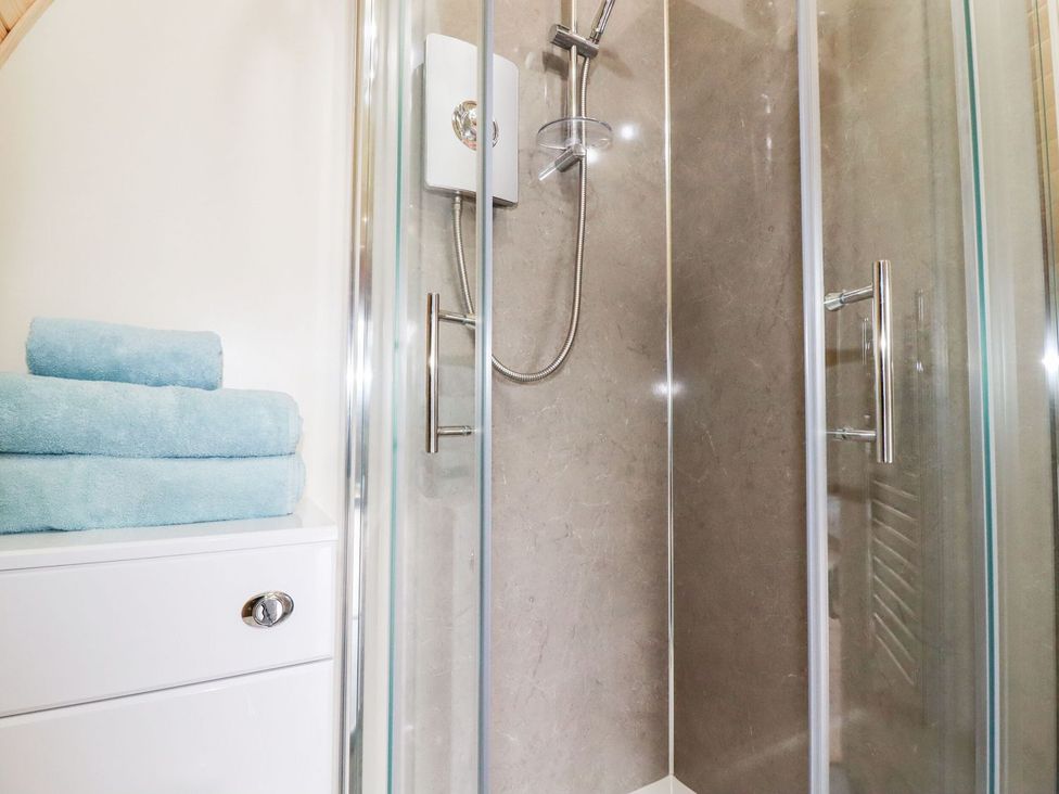 A shower with towels and a drawer unit at Barry in Polgooth