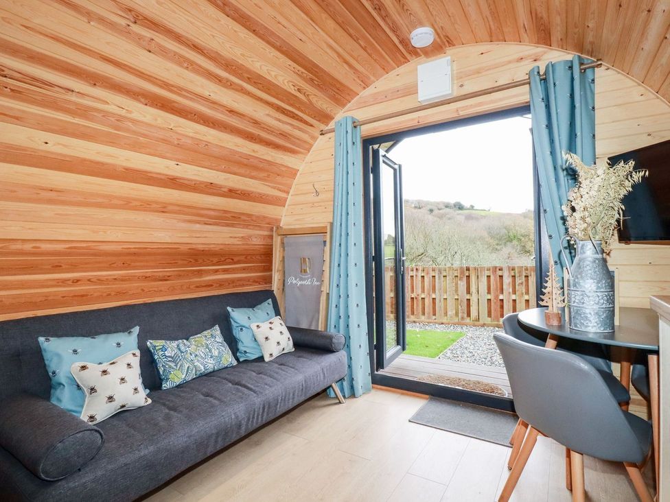 A living room with a sofa and a table at Vic in Polgooth