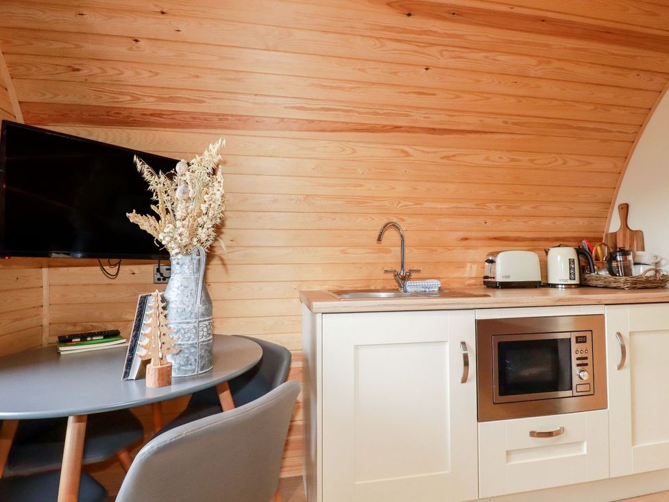 A kitchen with a sink, microwave, and television at Vic in Polgooth