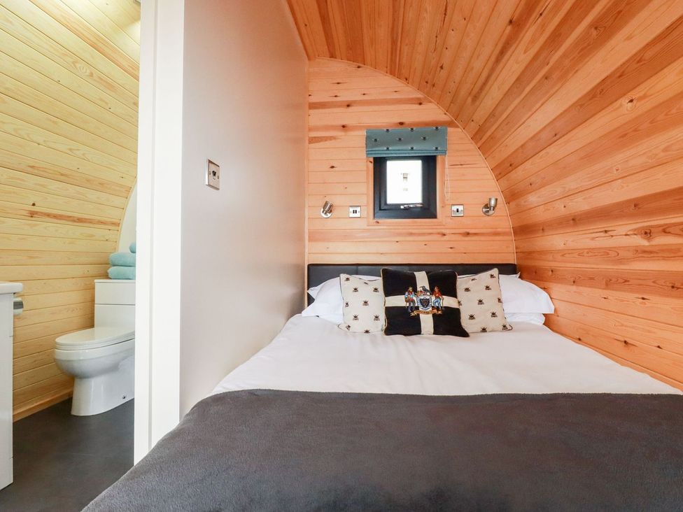 A bedroom with a bed and a bathroom at Vic in Polgooth