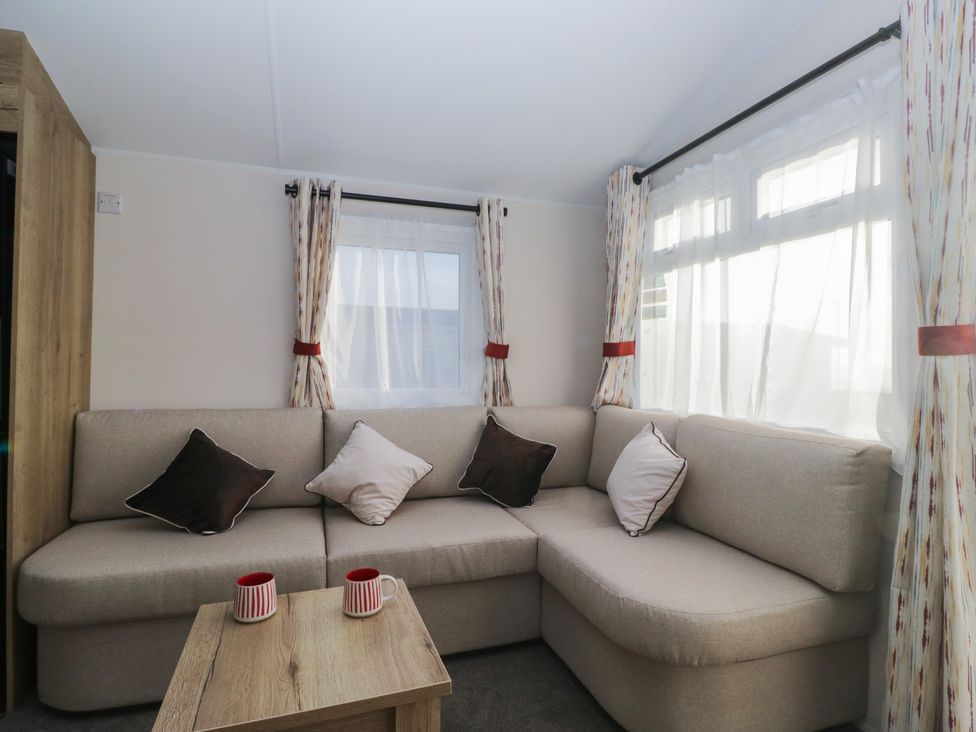 A living room with a corner sofa and a table at Mobility Friendly Caravan St Bees