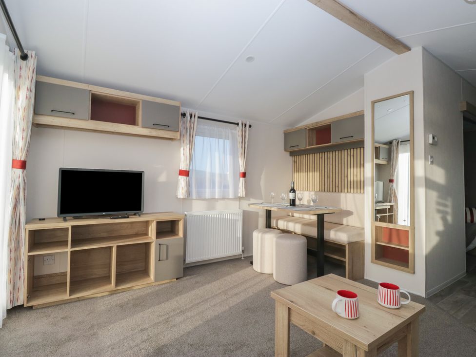A living room with a tv and dining table at Mobility Friendly Caravan in St Bees