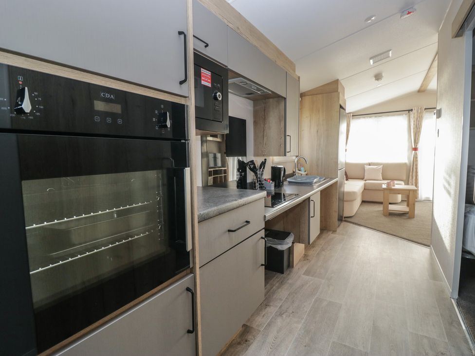 A kitchen with appliances and seating area at Mobility Friendly Caravan in St Bees
