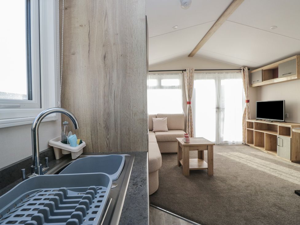 A living room with a sofa and television at Mobility Friendly Caravan in St Bees