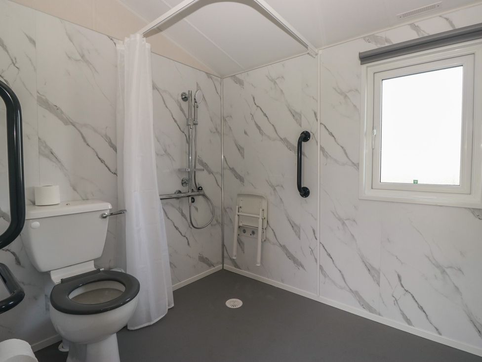 A bathroom with a toilet and shower at Mobility Friendly Caravan in St Bees