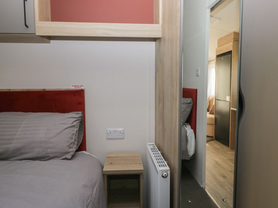 A bedroom with a bed and bedside table at Mobility Friendly Caravan in St Bees