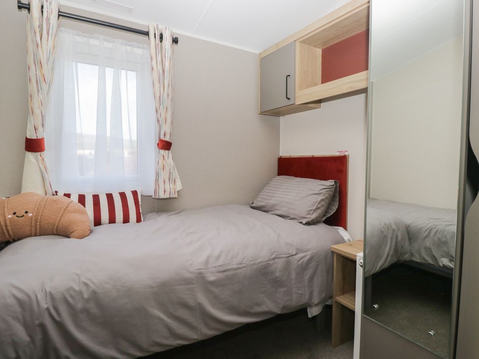 A bedroom with a bed and shelf at Mobility Friendly Caravan St Bees