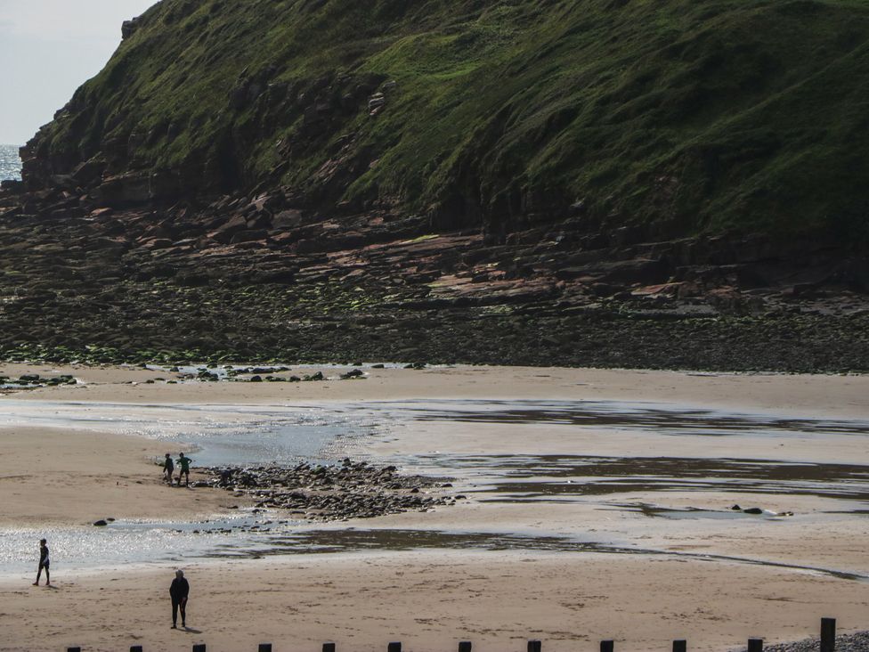 A beach with rocks and people at St Bees