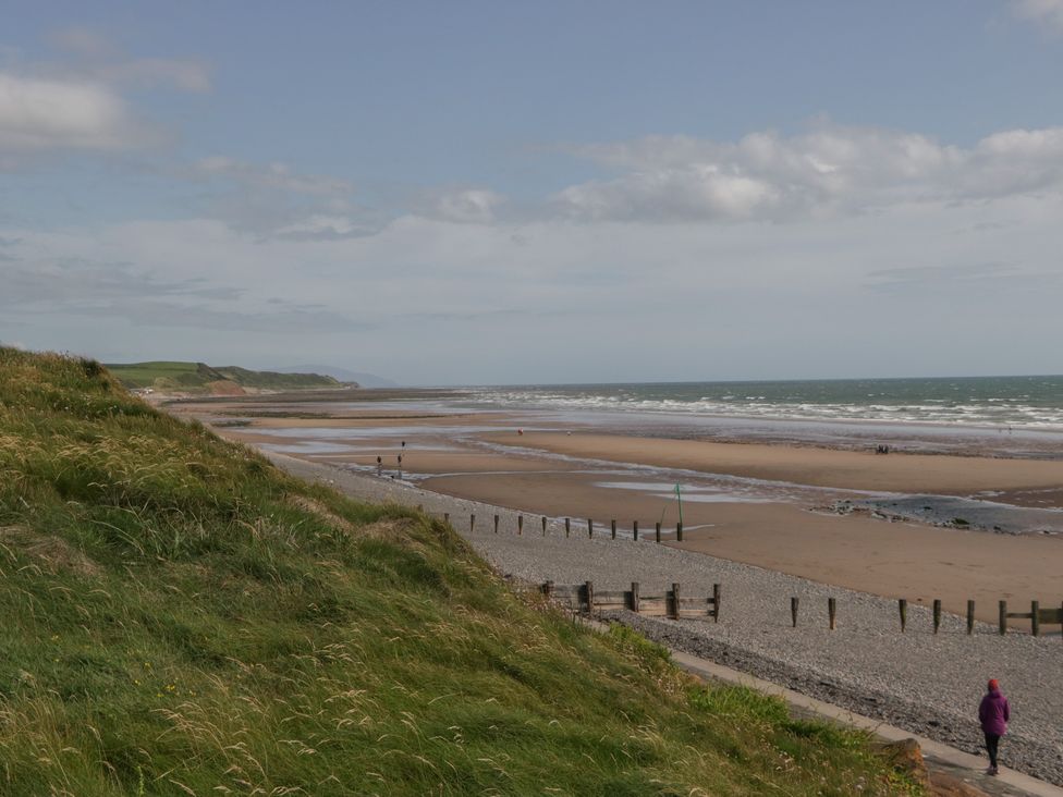 A beach with people walking along the shore at Mobility Friendly Caravan in St Bees