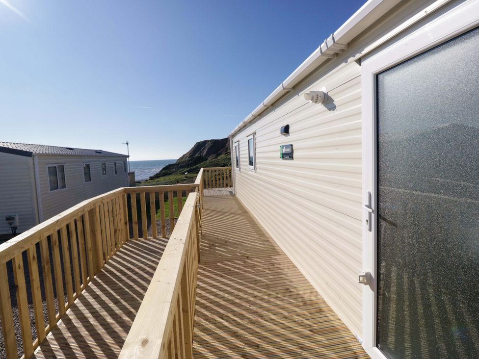 A decking area outside a building with a view of the sea at Guillemot in St Bees