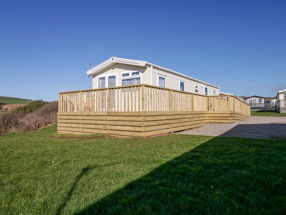 A house with a wooden deck and grass at Guillemot in St Bees