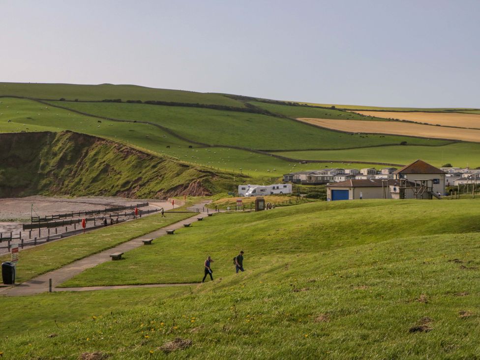 A landscape with people walking near caravans at Guillemot St Bees