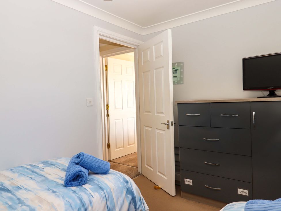 A bedroom with a bed and a dresser at Beachside