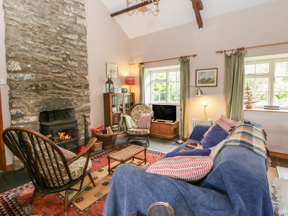 A living room with a fireplace and sofa at Tyn Y Fron in Brynherbert near Llanrhystud