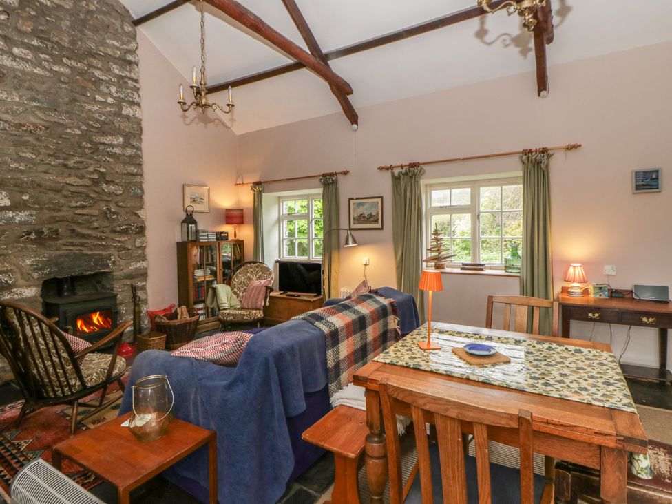 A living room with couch and fireplace at Tyn Y Fron Brynherbert near Llanrhystud