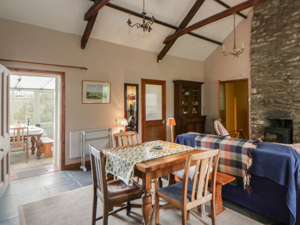 A dining room with a table and chairs at Tyn Y Fron in Brynherbert near Llanrhystud