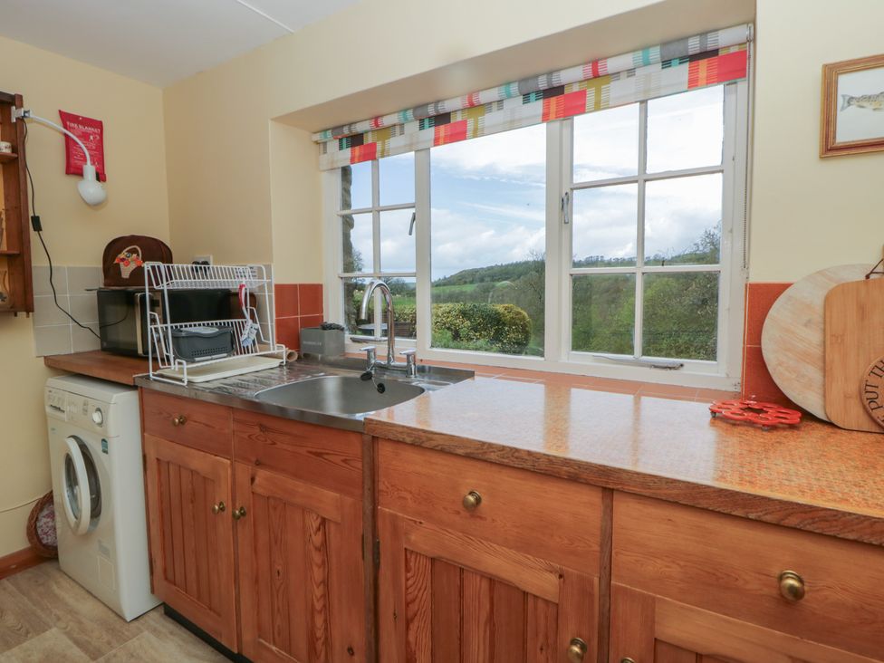 A kitchen with a sink and window at Tyn Y Fron Brynherbert near Llanrhystud
