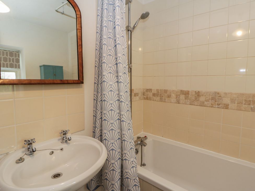 A bathroom with a bathtub and sink at Tyn Y Fron in Brynherbert near Llanrhystud
