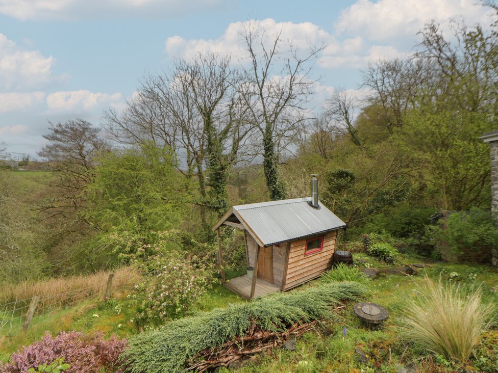 A cabin in a garden area near trees at Tyn Y Fron in Brynherbert near Llanrhystud