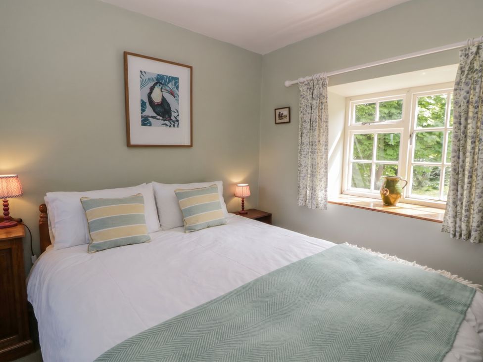 A bedroom with a bed and window at Tyn Y Fron in Brynherbert near Llanrhystud