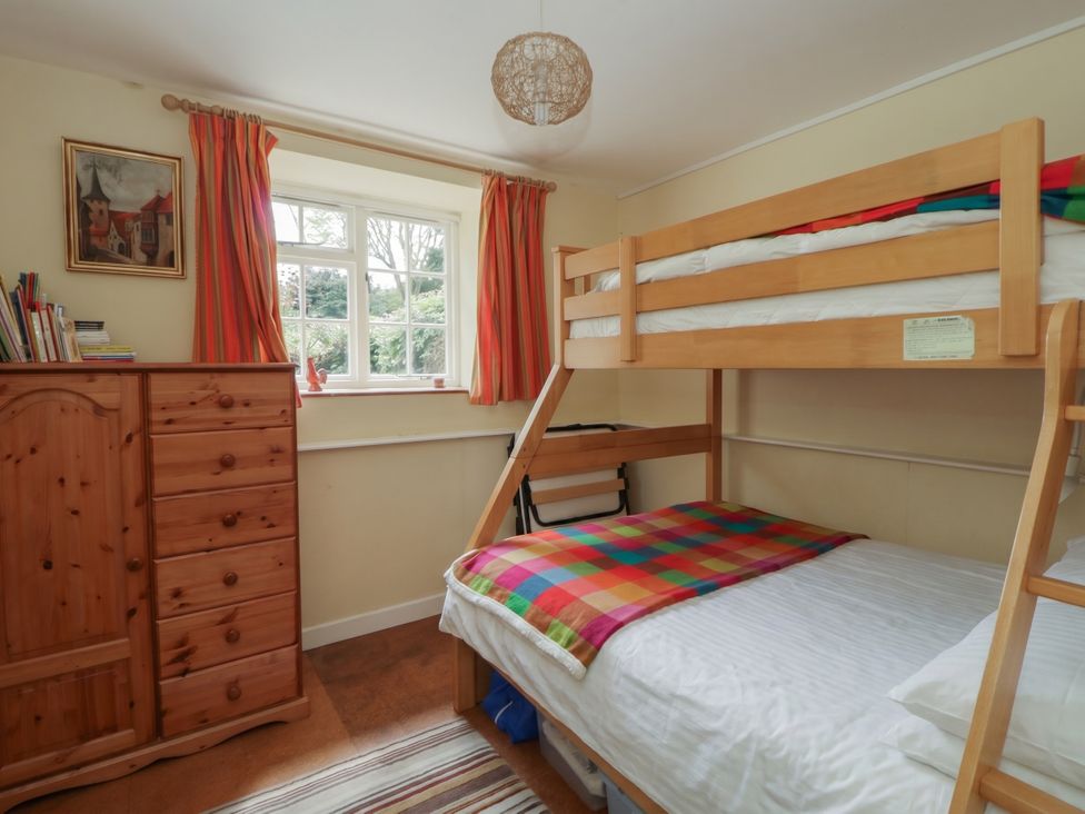 A bedroom with a bunk bed and a dresser at Tyn Y Fron Brynherbert near Llanrhystud