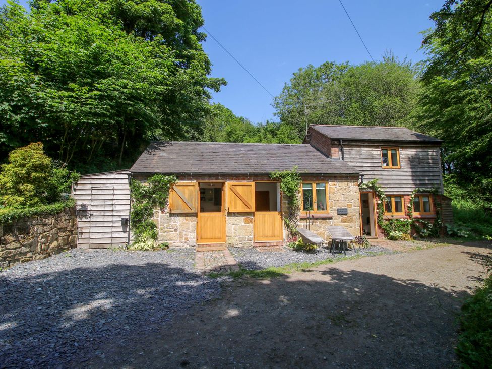 An exterior view of a cottage with trees in the background at The Lime Kiln Keepers Cottage in Ellesmere