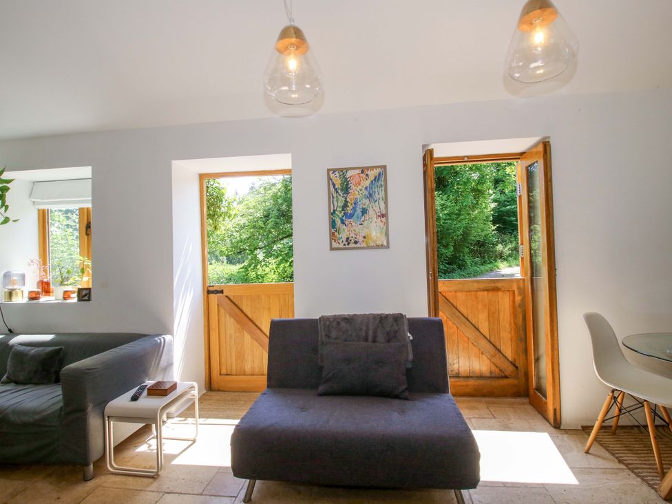 A living room with a sofa and doorways at The Lime Kiln Keepers Cottage in Ellesmere