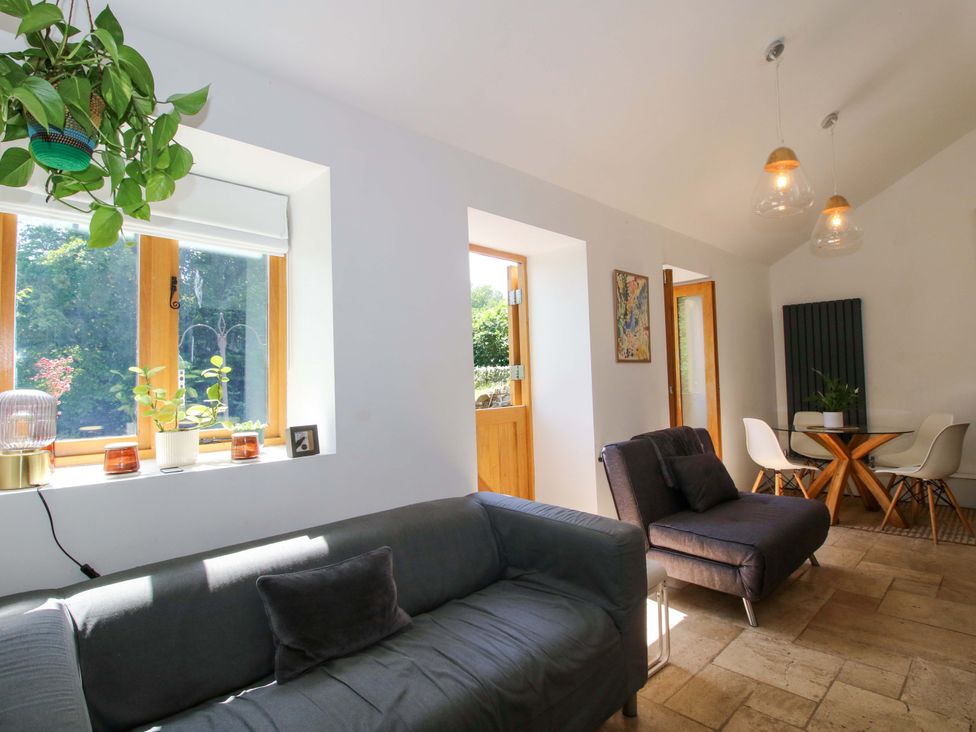 A living room with a sofa and dining area at The Lime Kiln Keepers Cottage in Ellesmere